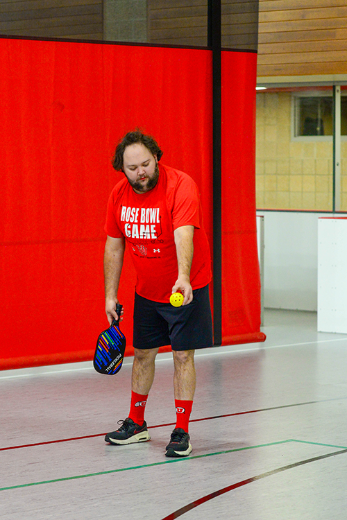 Male standing playing adaptive pickleball